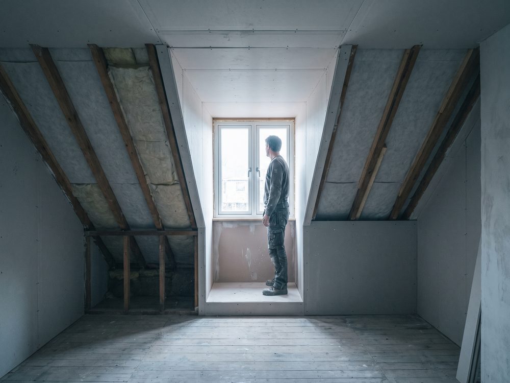 Zolderkamer met een dakkapel die een strook met volle stahoogte maakt naast de schuine dakvlakken