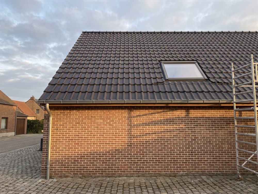 Afgewerkte dakrenovatie met nieuwe antracietkleurige pannen en een nieuwe zinken dakgoot