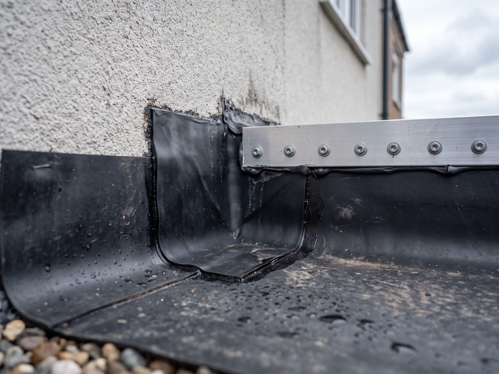 EPDM-membraan opgewerkt in een binnenhoek tegen een muur, met een voorgevormd hoekstuk en een klemprofiel